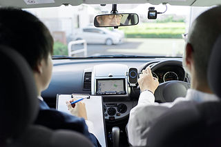 Instructor taking notes on a clipboard in a car