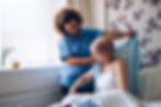 Home Caregiver helping a senior woman get dressed in her bedroom