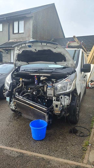 A car with its hood open, revealing a bucket placed in the front
