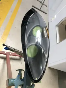 Close-up of an oval-shaped car headlight assembly in a workshop