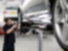 Mechanic fitting a car tyre in auto repair shop