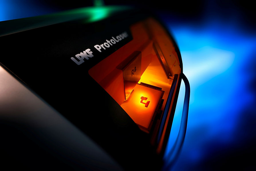 High tech engineering workspace showing precision laser routing machine in operation