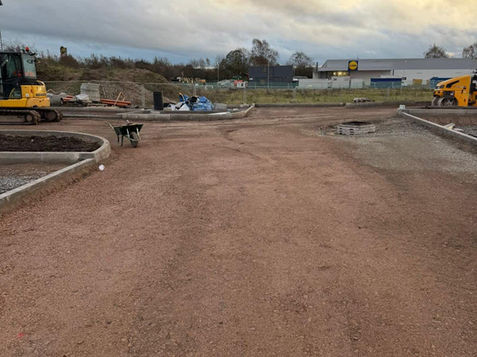 Construction site with gravel pathway, surrounded by machinery