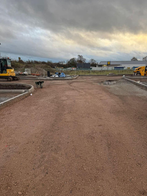 Construction site with gravel pathway, surrounded by machinery
