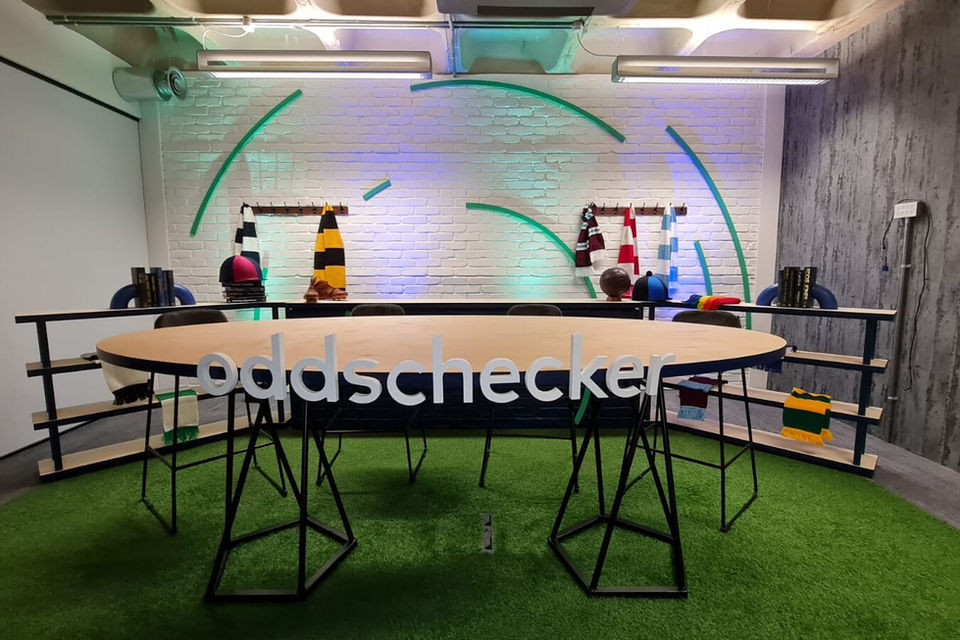 Modern conference room with a large, oval wooden table on a green carpet