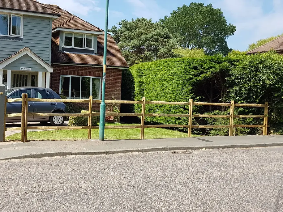 A house with a parked car and a wooden fence