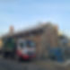 A truck parked in front of a building under construction, surrounded by scaffolding