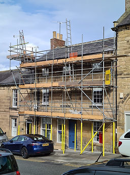 A building under construction, surrounded by scaffolding for renovation