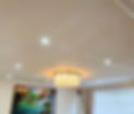 A modern living room with ceiling lights and a crystal chandelier