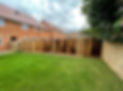 A freshly completed wooden perimeter fence bounding a neat backyard grass lawn
