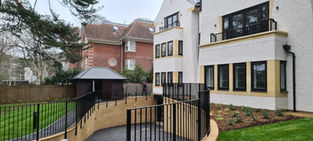 Backyard of modern houses with a wooden ramp and a person in the distance