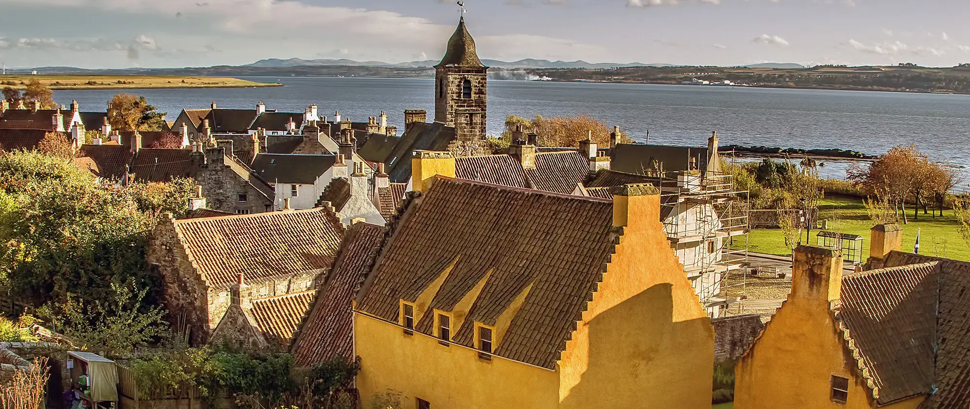 Aerial overview of historic rooftop architecture bordering a blue harbor waterfront
