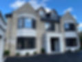 Modern two-story brick house with large bay windows and a centrally located front entrance