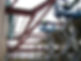 Construction site with workers on a scissor lift installing red steel beams