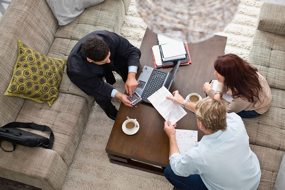 Business team collaborating on tax strategies around a laptop and paperwork