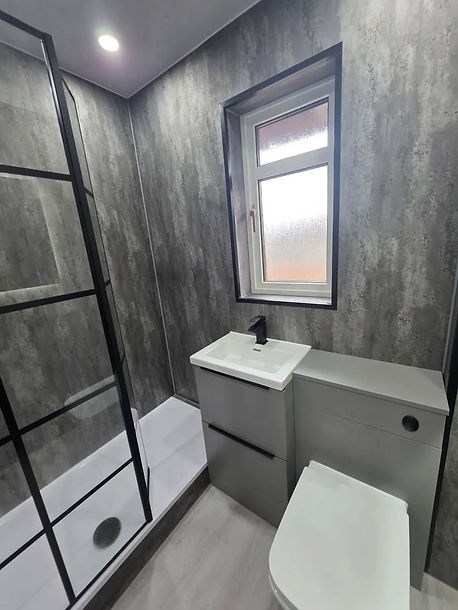Modern bathroom with gray textured walls, featuring a glass shower enclosure