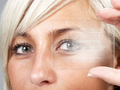 Focused female technician holding up a transparent circuit film layout asset