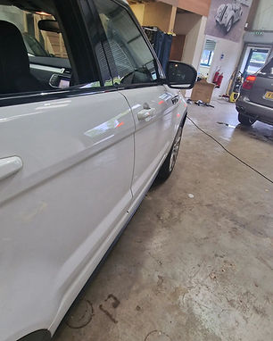 Side view of a white car in a garage