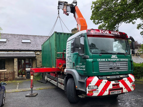 A truck with a container parked in front of a house