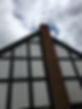 Tudor-style house with a tall brick chimney against a cloudy sky