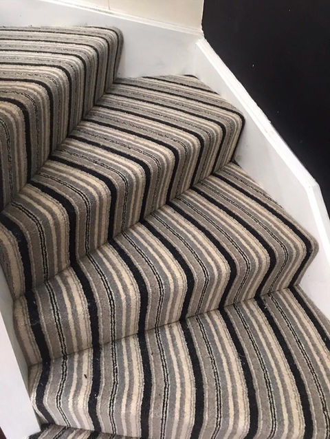 A close-up of a striped carpet on a staircase