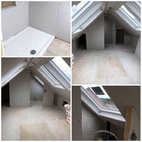 A partially finished attic space with skylights, drywall, and a shower base, awaiting final touches and flooring