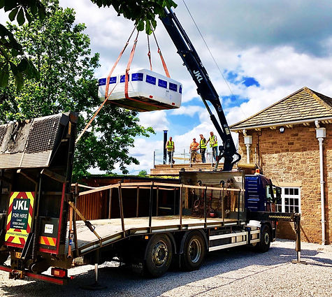 A truck lifting a large object off a building