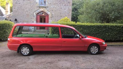 A red hearse outside church