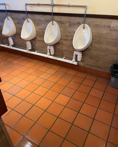 An orange tiled restroom floor after cleaning