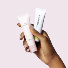 A hand holding skincare creams.