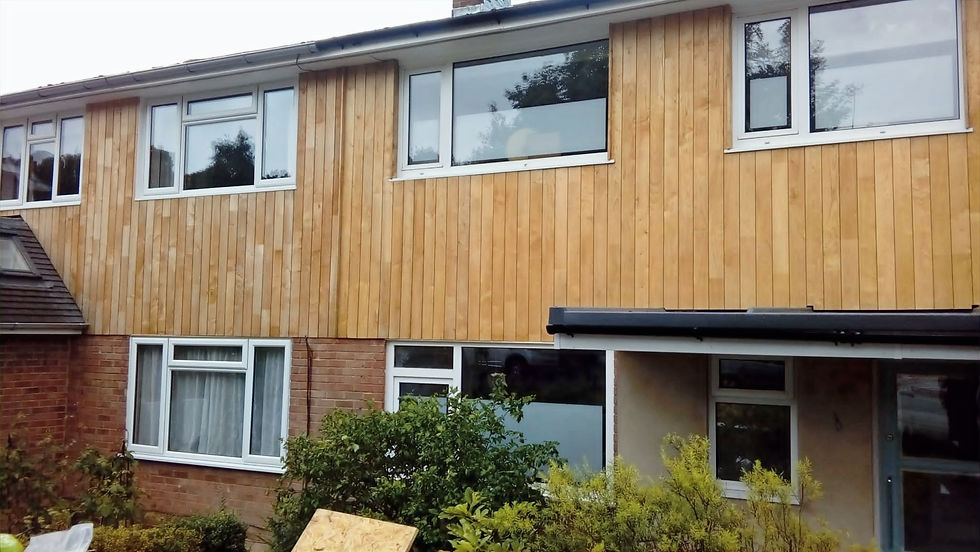 a residential house undergoing a modern exterior renovation with newly installed vertical timber wall cladding