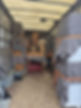A moving truck's interior packed with covered furniture