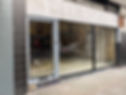 Empty storefront with large glass windows and unfinished interior