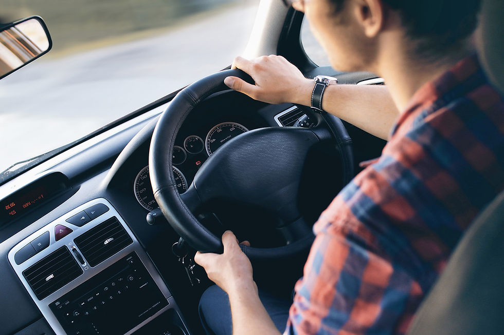 Driver's hands holding a steering wheel wearing a wristwatch