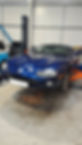 A blue car is being repaired in a garage