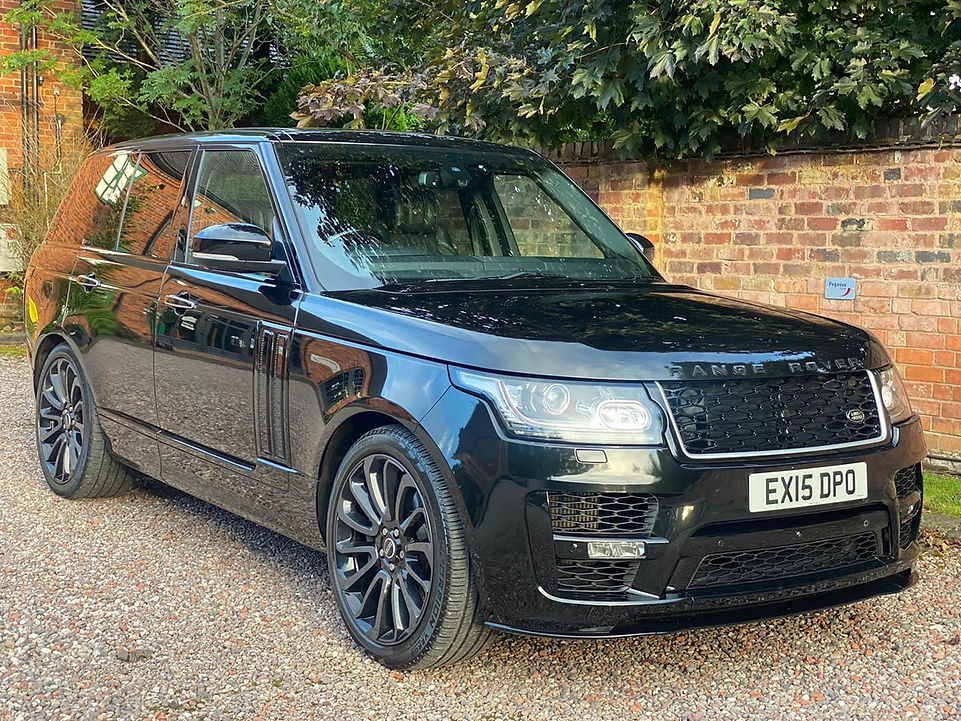 A sleek black Range Rover parked on a gravel driveway