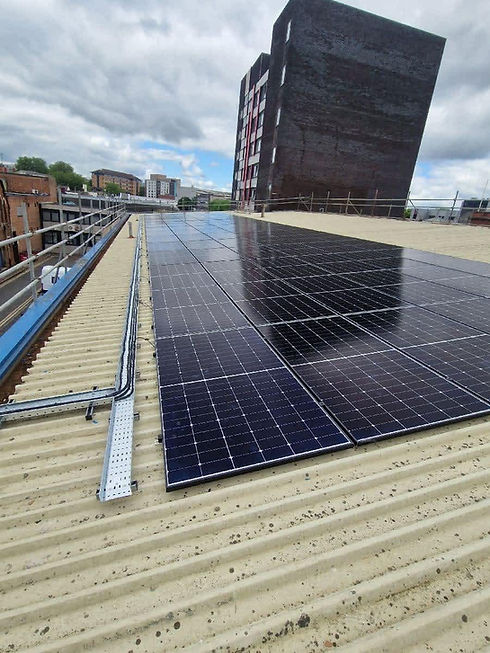 Rooftop view of sleek, black solar panels mounted on a metal roof grid