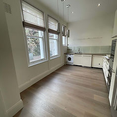 Bright, empty room with freshly installed wooden flooring and large windows