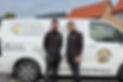 Two technicians standing proudly next to a branded corporate service van
