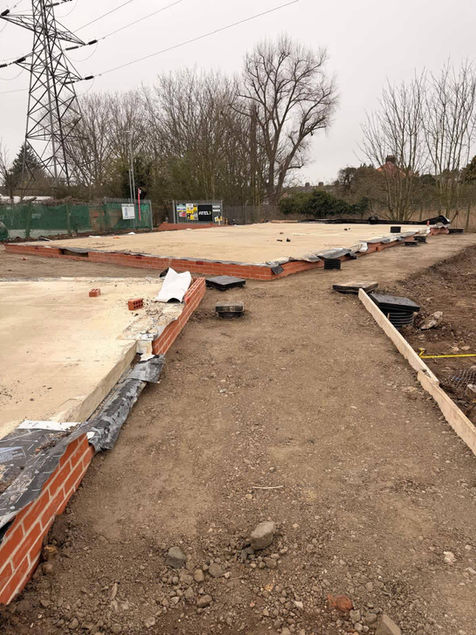 Construction site with concrete foundations and exposed brickwork