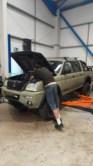 A man repairs a truck inside a garage