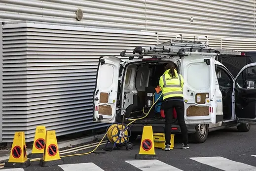 Technician standing at the open rear doors of a commercial service van
