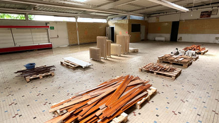 Matériaux de réemploi présenté dans un espace de vente en pied de chantier. Les matériaux sont stockés sur des palettes afin de faciliter la logistique.