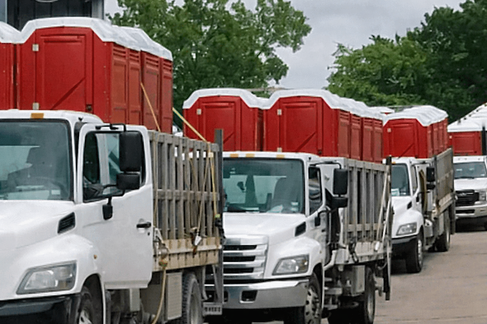 Trucks lined up with red portable toilets