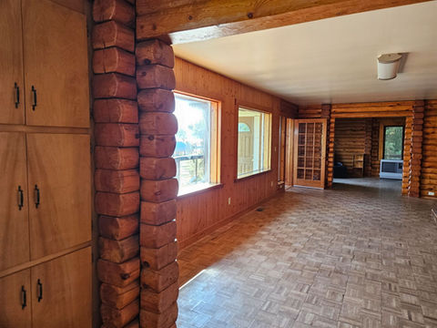 Large east facing windows overlooking water, deck entry, wood log interior den & living area, Waterfront Homestead for sale, Kupreanof Island Alaska