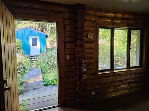 2nd floor - Log interior, facing west, back entry area looking outside to generator shed, Waterfront Homestead for sale, Kupreanof Island Alaska