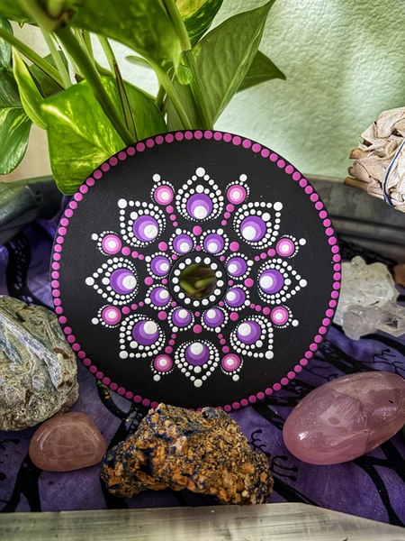 A Mandala hand-painted in hues of lilac and purple.