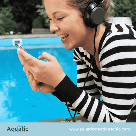 Smiling woman in headphones checks a phone by a bright blue pool; Aquatic Creations logo and aquaticcreationsohio.com at bottom.