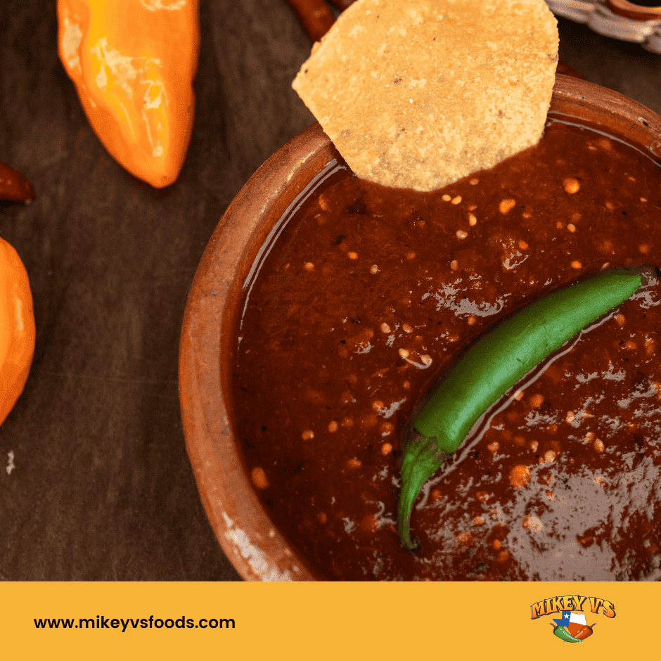 hot sauce in bowl with chip and chili pepper