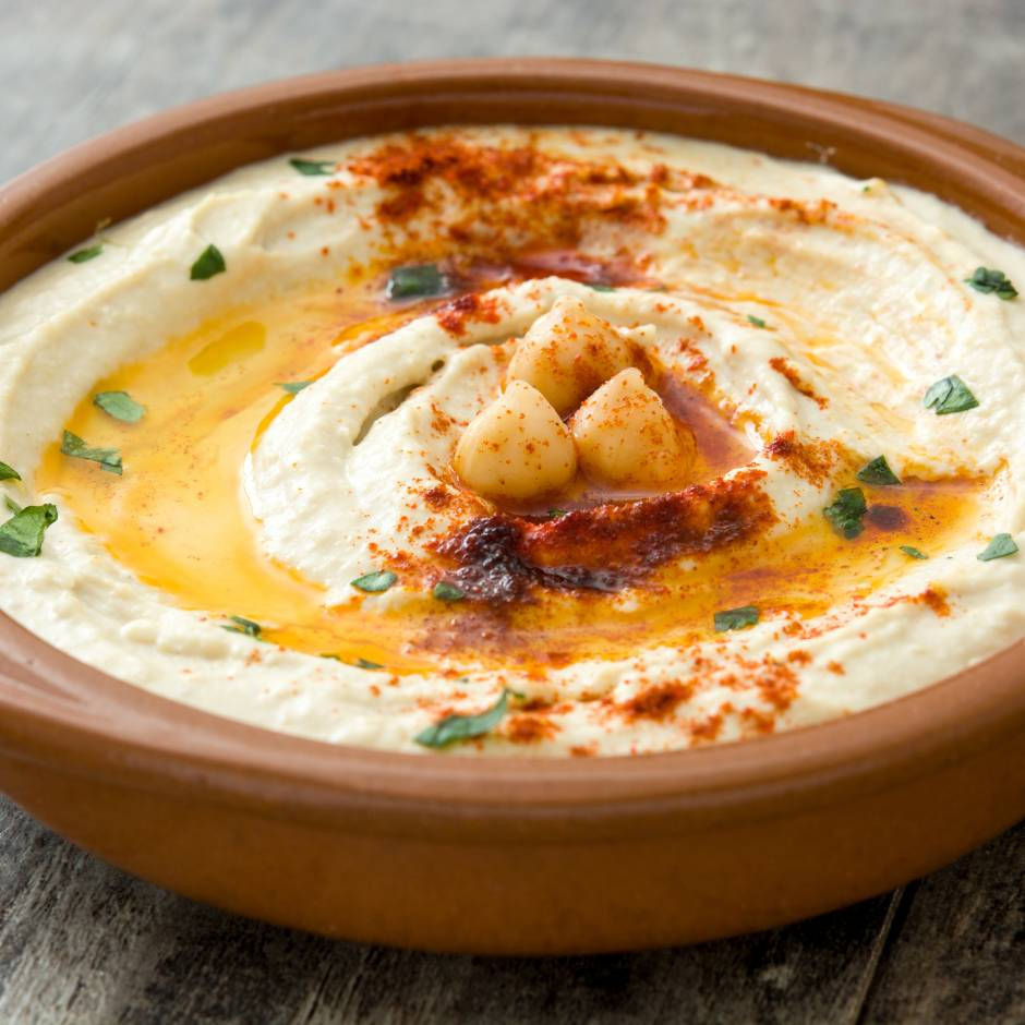 freshly made hummus in a bowl with sauce